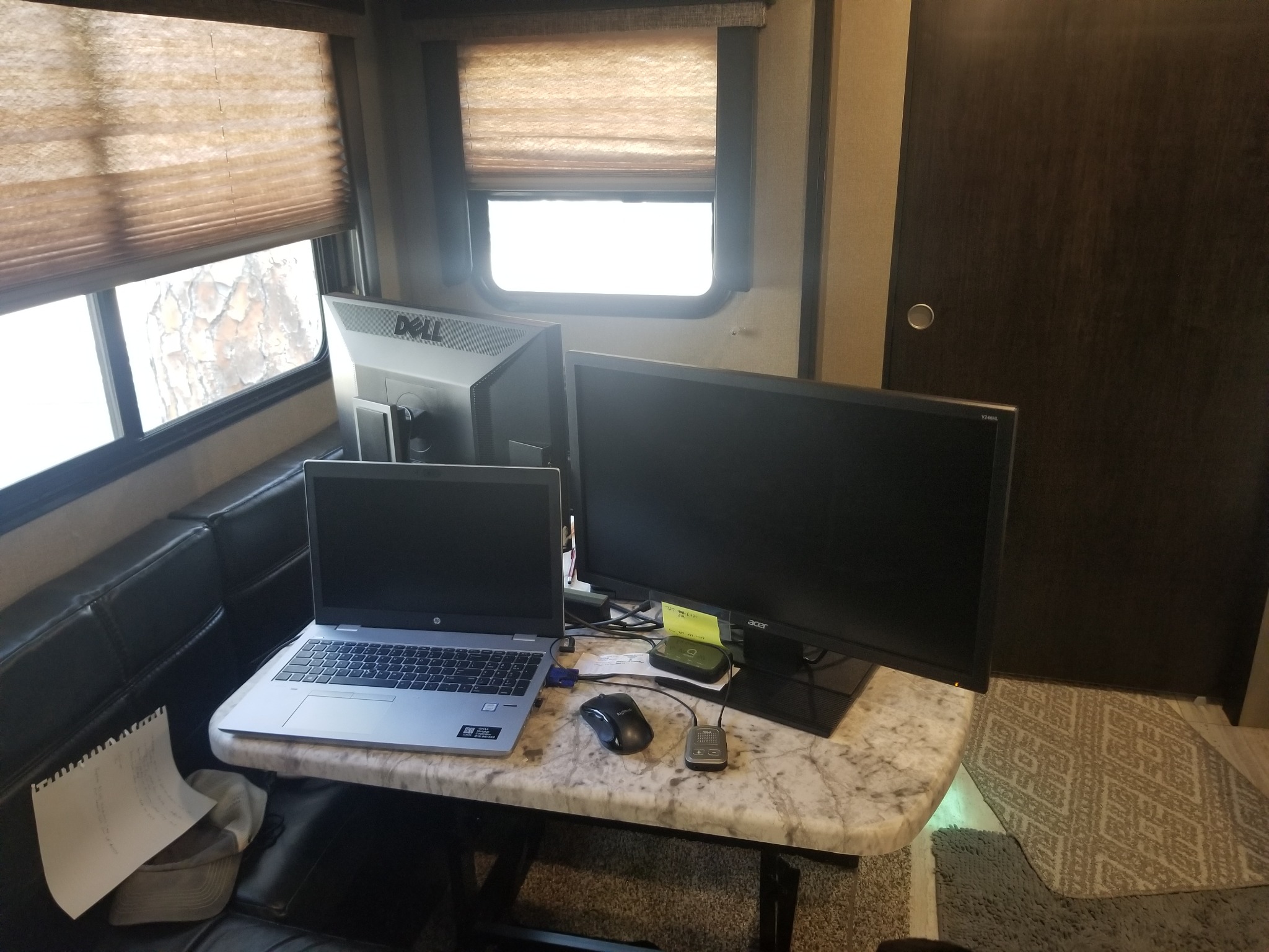 Laptop and monitors arranged at our RV dinette for remote work