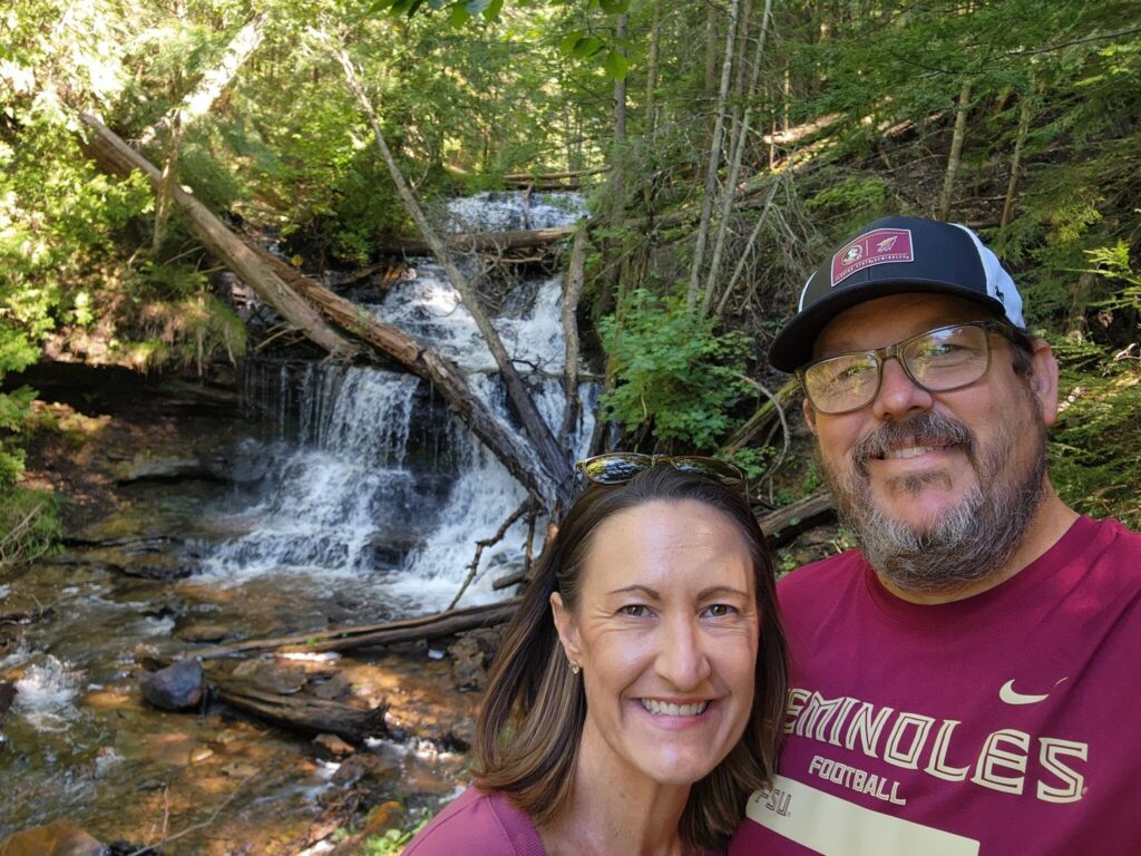 Scott and Kristen beside a wooded waterfall